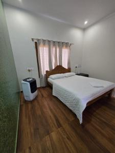 a bedroom with a large bed and a window at Dsouza Stay in Mysore +59 photos