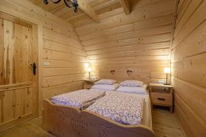 a bedroom with a bed in a log cabin at Sun&Ski Maciejówka Domki Białka Tatrzańska in Białka Tatrzańska
