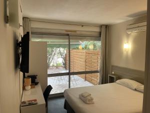 a hotel room with a bed and a door to a patio at Hôtel Lapeyronie in Montpellier