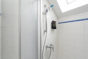 a shower in a white tiled bathroom at Spacious 80 m2 Apartment I 3 Rooms I Up to 8 Guests I Near Train Station in Steyr +35 photos