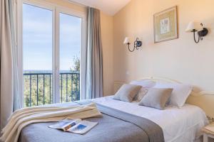 a bedroom with a bed and a large window at Résidence Pierre & Vacances Les Restanques du Golfe de Saint-Tropez in Grimaud