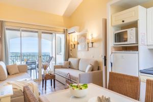 a kitchen and living room with a couch and a table at Résidence Pierre & Vacances Les Restanques du Golfe de Saint-Tropez in Grimaud +89 photos
