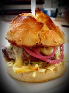 a sandwich with cheese and onions on a plate at Gasthaus Alpenrose in Innerferrera