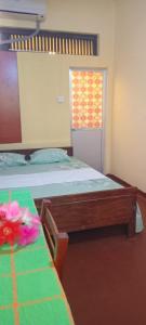 a bedroom with two beds and a table and a window at Lighthouse Peacock Villa in Dondra West