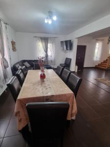 a dining room with a table and leather chairs at Vila Felicia in Borşa