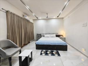 a bedroom with a bed and a chair at Rudra BNBF in Gandhidham