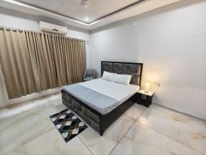a bedroom with a large bed and a window at Rudra BNBF in Gandhidham