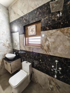 a bathroom with a toilet and a sink at Rudra BNBF in Gandhidham +2 photos