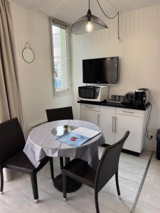 a dining room with a table and chairs and a tv at Antibes Port - Terrasse - Parking - Piscine in Antibes