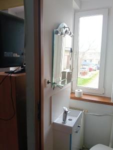 a bathroom with a toilet and a sink and a window at Noclegi Adam in Radonia