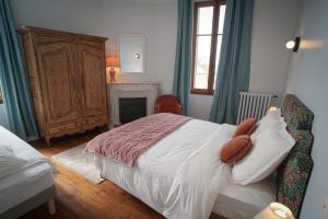 a bedroom with a large bed and a fireplace at La Leugnyçoise in Leugny