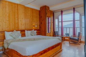 a bedroom with a bed and a large window at Mashobra Heights By shrpl in Kīar