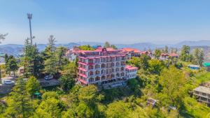 an aerial view of a building on a hill with trees at Mashobra Heights By shrpl in Kīar