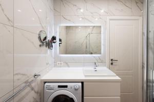 a white bathroom with a washing machine and a sink at Central Suites in Lugano +51 photos