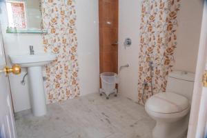 a bathroom with a toilet and a sink and a shower at Mashobra Heights By shrpl in Kīar +88 photos
