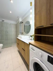 a washing machine in a bathroom with a sink at The Calaya - Aparthotel Saranda in Sarandë