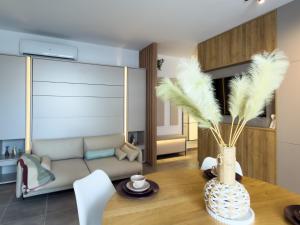 a living room with a table and a couch at The Calaya - Aparthotel Saranda in Sarandë +276 photos