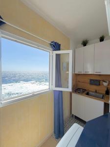 a kitchen with a window with a view of the ocean at apartamento el camarote in Fasnia