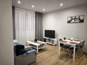 a living room with a couch and a table and a television at Apartamento La Mandrágora in Arenas de Cabrales