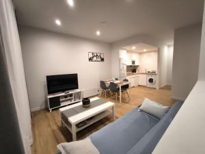 a living room with a blue couch and a table at Apartamento La Mandrágora in Arenas de Cabrales