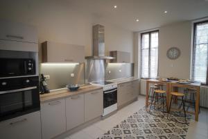 a kitchen with white cabinets and a stove top oven at La Leugnyçoise in Leugny