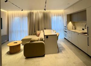 a kitchen and a living room with a couch and a table at Apartaments Jaunyste Free parking, Self Check - in in Klaipėda +15 photos