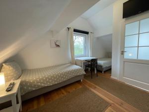 a bedroom with two beds and a desk and a window at Pension Försterhof in Angermünde