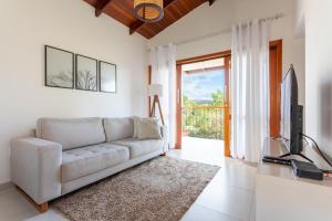 a living room with a couch and a television at Cerrado Ville in Alto Paraíso de Goiás