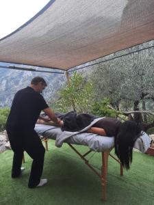 a man helping a woman laying on a bed at Chalet Zenitude in Breil-sur-Roya