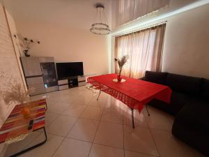 a living room with a red table and a television at Igor House in Jūrmala