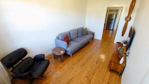 a living room with a blue couch and a wooden floor at Home in Newtown in Toowoomba +5 photos