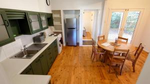 a kitchen with a wooden table and a refrigerator at Home in Newtown in Toowoomba