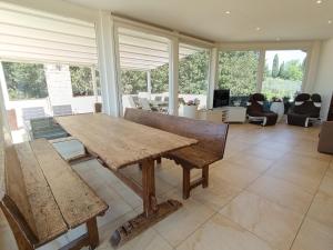 a wooden table and bench in a room with windows at Appartamento con piscina in Villa in Florence