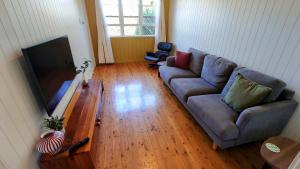 a living room with a couch and a flat screen tv at Home in Newtown in Toowoomba