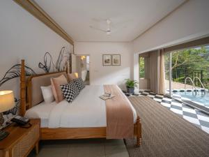 a bedroom with a large bed and a pool at Blanket Riverside Resort and Spa in Munnar