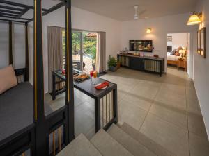 a living room with a table and a room with a couch at Blanket Riverside Resort and Spa in Munnar