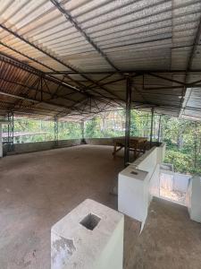 an empty building with a table and a bench at Hibisco Hideout in Meenangadi