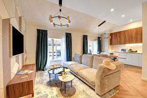 a living room with a couch and a kitchen at Central Suites in Lugano