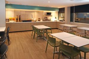 a restaurant with tables and chairs and a kitchen at City Express by Marriott Reynosa in Reynosa