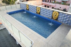 a swimming pool with lions painted on the side of a building at JPR Heritage Villa in Pondicherry