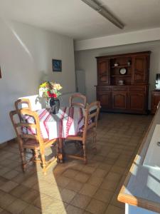 a dining room with a table and chairs and a cabinet at Le Petit Clos périgourdin in Église-Neuve-de-Vergt +4 photos
