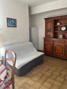 a bedroom with a bed and a wooden cabinet at Le Petit Clos périgourdin in Église-Neuve-de-Vergt