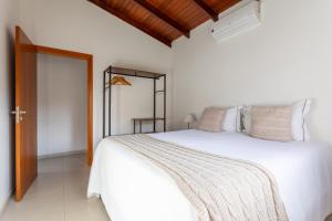 a bedroom with a white bed and a mirror at Cerrado Ville in Alto Paraíso de Goiás