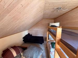 a small attic room with a bunk bed and a ladder at Igor House in Jūrmala