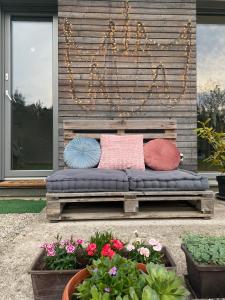 a bench with four pillows on it next to some flowers at River & Forest Escape, Private Garden Room near Ljubljana in Preddvor