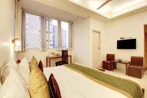 ein Hotelzimmer mit Bett und Fernseher in der Unterkunft Marks in Noida