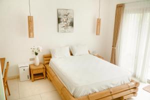 a bedroom with a large bed with white sheets at Casa Solisa in Kerobokan +12 photos