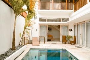 an indoor pool in a house with a palm tree at Casa Solisa in Kerobokan