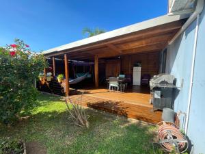 a house with a wooden deck with a table and chairs at chambre "suite parentale" Villa Hermès in Saint-Pierre