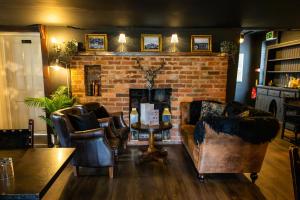 a living room with couches and a brick fireplace at The Kings Head Rye in Rye